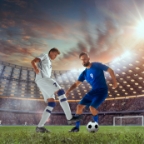 Footballers competing under stadium lights